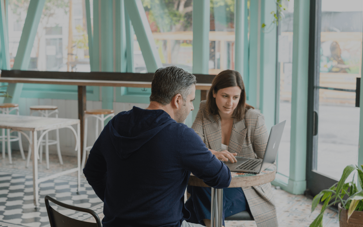 Two people talking about business with a computer