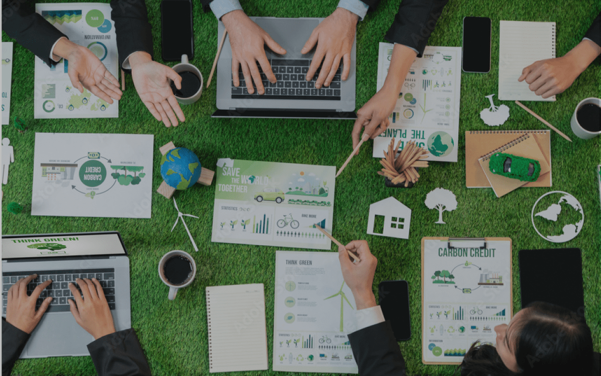 People sitting around a green table working on sustainability