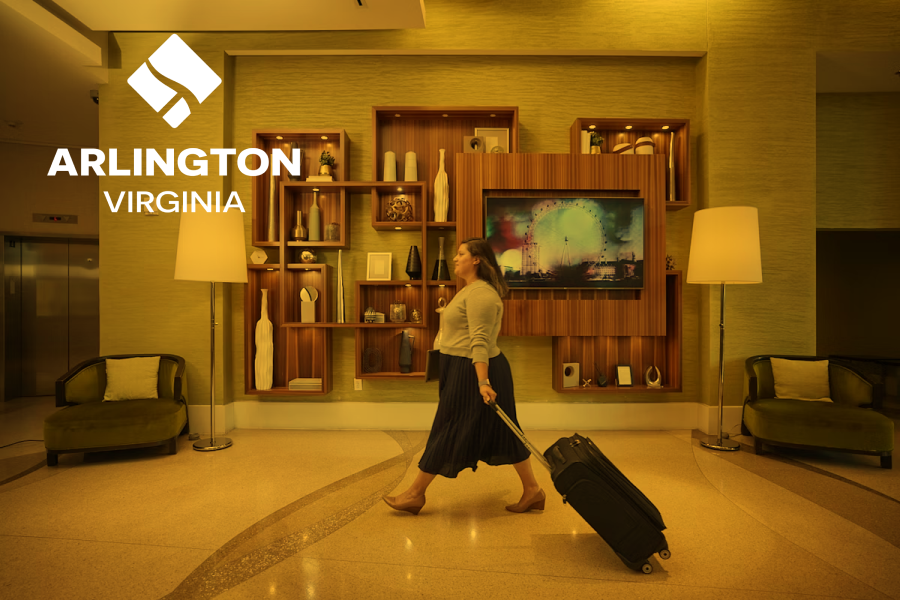 Woman walking through stylish hotel lobby. Arlington virginia logo overlaid top left