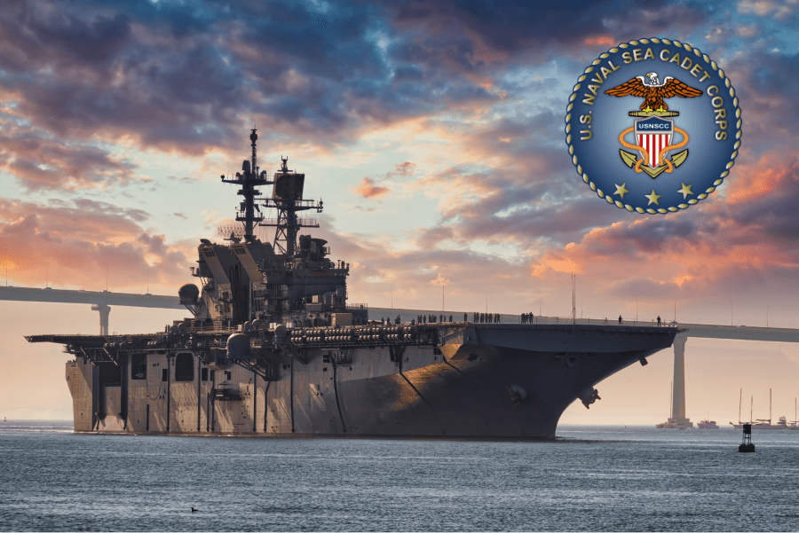 US Navy ship in the sea in front of large bridge with sunset in background. US Naval Sea Cadet Corps logo in top right