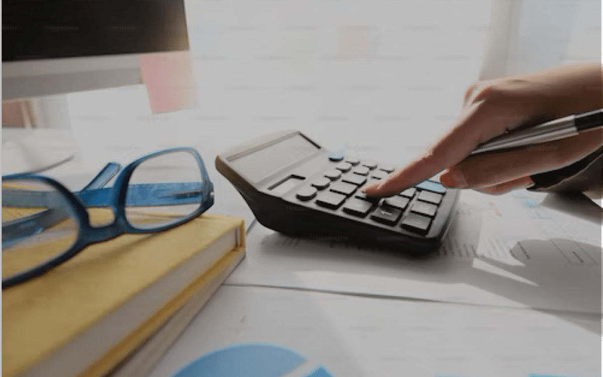 person typing on a calculator at a desk