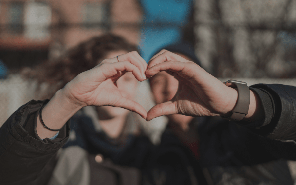 Two people making heart with their hands