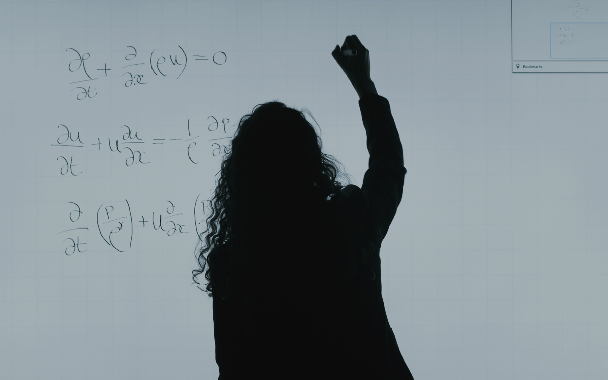 Woman standing in front of whiteboard with math equations